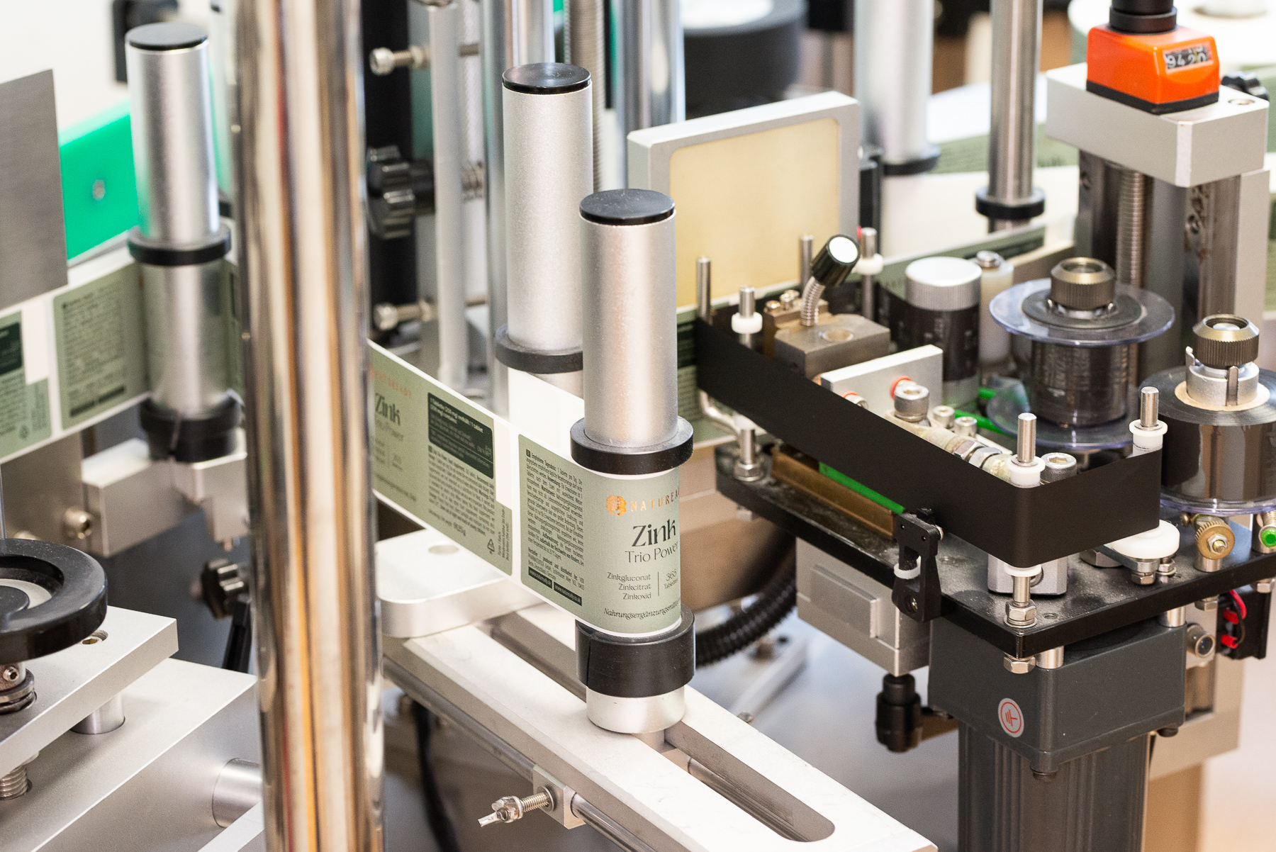 Automatic labelling machine applying labels to supplement bottles